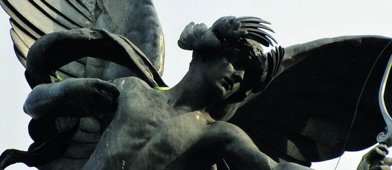 A close-up of a bronze statue depicting Eros, the Greek God of Love, with wings and intricate details in the design.