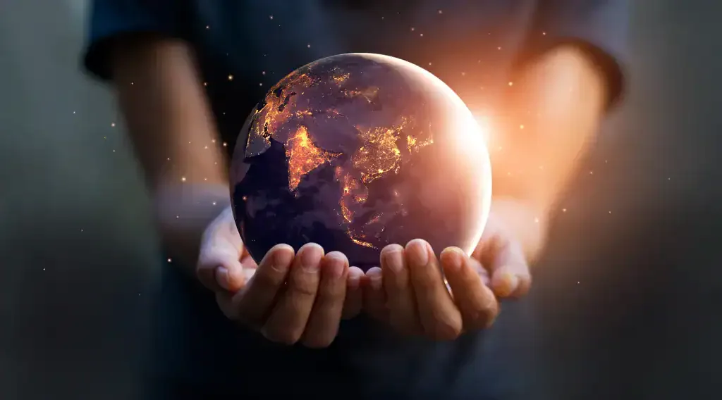Human hands gently holding a glowing Earth, representing a quiet yet profound global legacy.