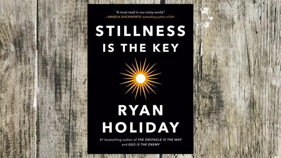 Book cover of Stillness Is the Key by Ryan Holiday on a wooden background